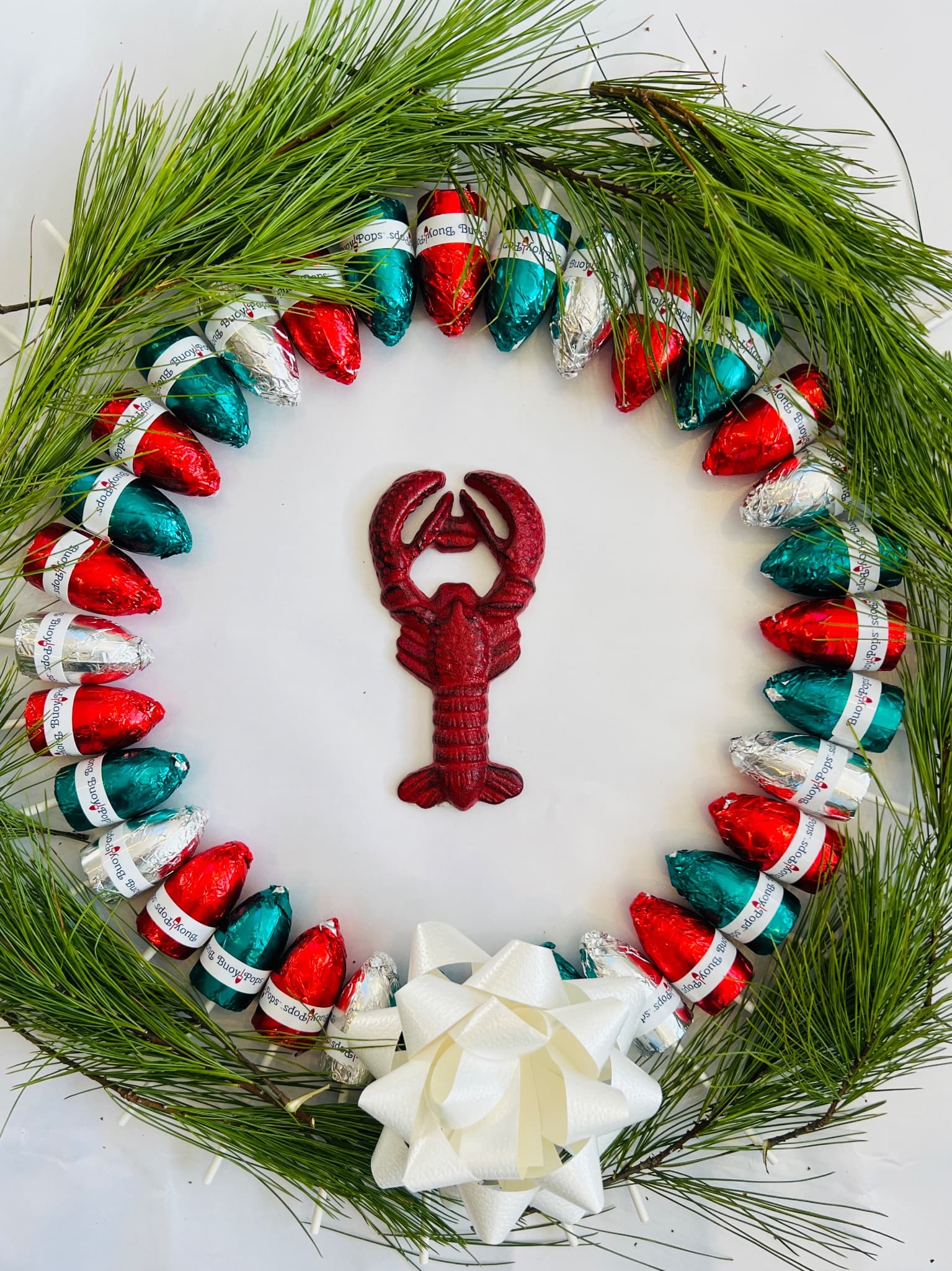 Festive Buoy Pops chocolates arranged with Maine pine and a lobster decoration